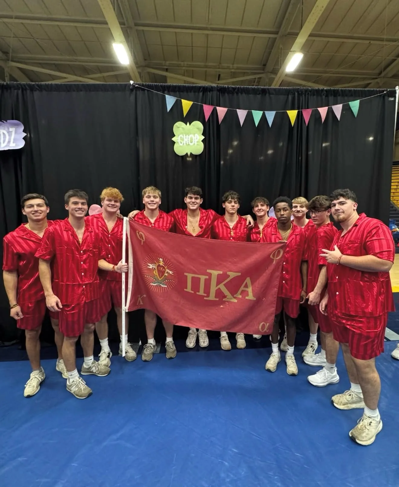 Two Pi Kappa Alpha members at chapter backdrop