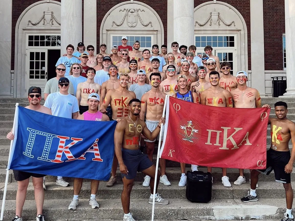 Pi Kappa Alpha members holding chapter flags